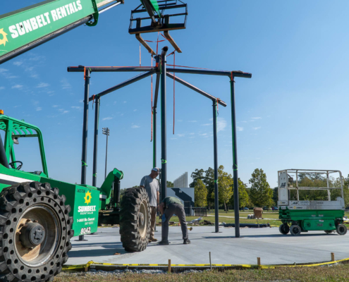 A machine places the centerpiece of a FitLot Outdoor Fitness Park.